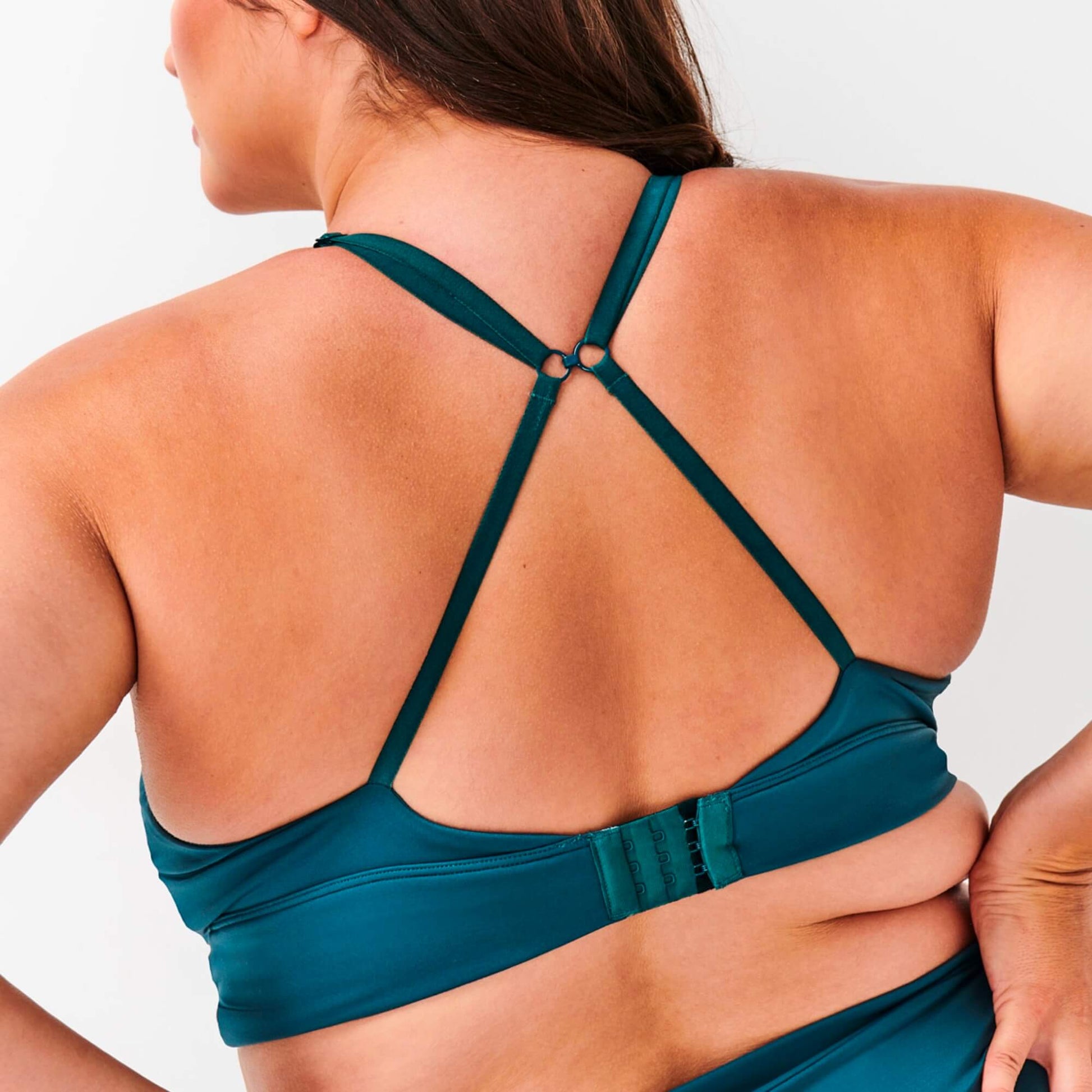 Model wears NipCo Teal Bra and shows the back straps and clasp